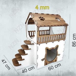 K&ouml;nnte beinhalten: Ein wei&szlig;es und braunes Katzenhaus aus Holz mit einer Plattform, Treppen und einer katzenf&ouml;rmigen &Ouml;ffnung. Das Haus ist 47 cm hoch, 40 cm breit und 60 cm tief. Das Haus ist aus 4 mm dickem Holz gefertigt.