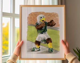 Può includere: Un'illustrazione ad acquerello incorniciata di una mascotte aquila che indossa una maglia verde e pantaloni bianchi. La mascotte ha piume marroni, un becco giallo ed è posizionata su un campo verde con uno sfondo di mattoni, stile pittorico.