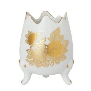May include: A white ceramic vase with a scalloped rim and three small feet. The vase is decorated with gold floral designs. The gold accents the white ceramic, creating a striking contrast. The vase is a decorative item.