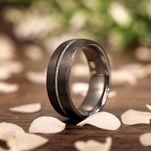 May include: A black tungsten carbide ring with two thin silver lines running around the band.