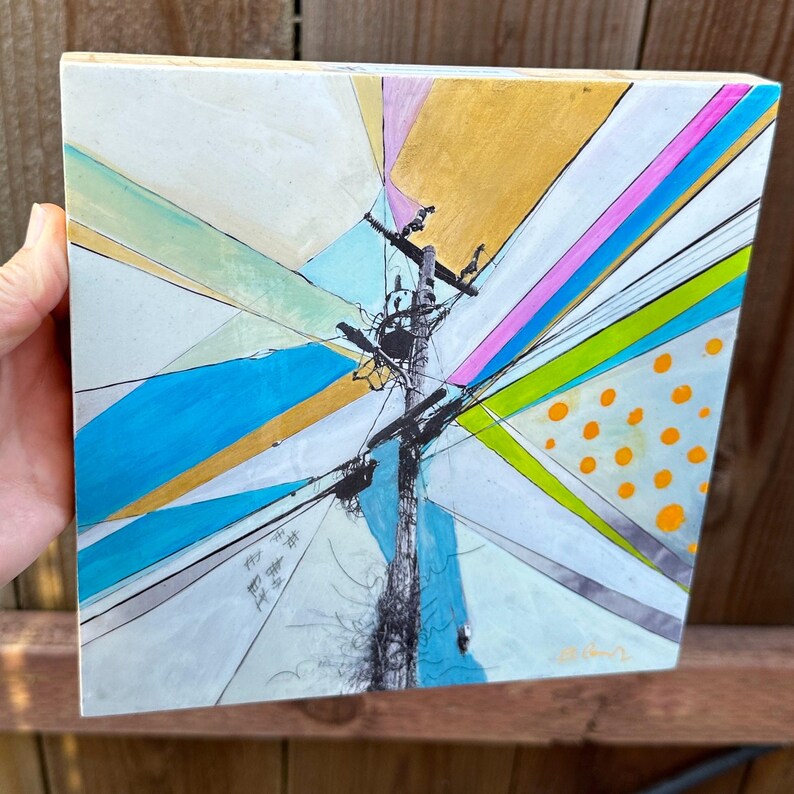 May include: Abstract painting on a wooden canvas featuring a central pole with lines radiating outwards in a variety of colors, including blue, green, yellow, pink, and white. The lines are intersected by a black and white pattern of dots.