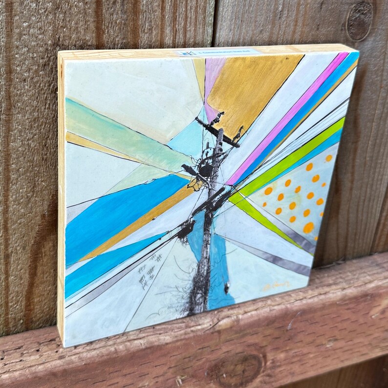 May include: Abstract painting on wood panel with a central black pole and colorful geometric shapes in blue, green, yellow, pink, and white.