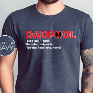 May include: A heather navy t-shirt with a red graphic that says "DADPOOL" with a Deadpool mask. The text below the graphic reads "[dead-pu:l] - noun like a dad, only cooler. [See also: handsome, funny]"