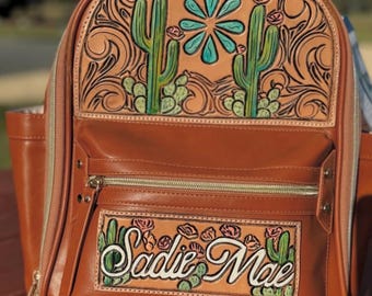 Mochila o bolso cambiador de cuero repujado
