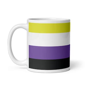 Puede incluir: Taza de cerámica blanca con el diseño de la bandera del orgullo no binario. La bandera presenta franjas horizontales en amarillo, blanco, morado y negro. La taza tiene un asa curva y un acabado brillante, adecuada para bebidas frías o calientes.