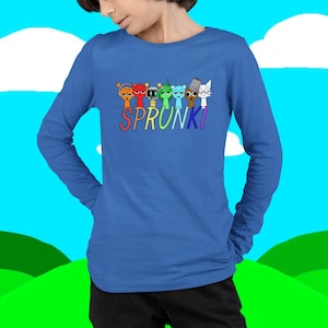 Puede incluir: Una camiseta azul de manga larga con la palabra "SPRUNKI" en letras coloridas. Encima de la palabra hay siete personajes de dibujos animados de varios colores. La camiseta es de un material suave.