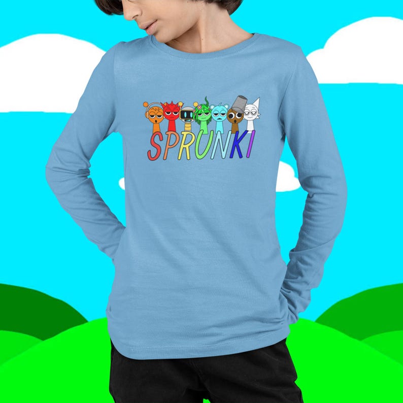 Puede incluir: Una camiseta de manga larga azul claro con la palabra "SPRUNKI" en colores arco&iacute;ris. Encima de la palabra hay siete personajes de dibujos animados con diferentes colores y expresiones. La camiseta es de un material suave.