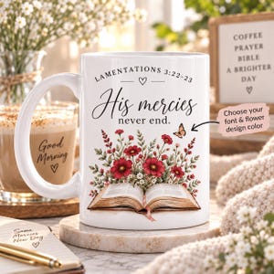 May include: A white ceramic mug featuring the text Lamentations 3:22-23 and His mercies never end. The design includes an open book with a bouquet of red flowers and a small butterfly. A pink note with text about font and color is attached.