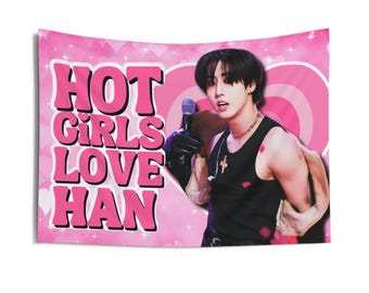 Puede incluir: Una bandera rosa y blanca con el texto "HOT GIRLS LOVE HAN" en letras rosas. Un hombre con cabello negro canta en un micrófono. Lleva una camiseta sin mangas negra y un collar plateado.