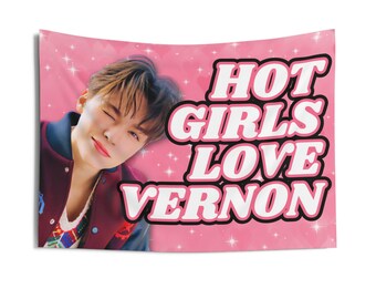 May include: Pink tapestry with the text "HOT GIRLS LOVE VERNON" in white and black lettering. The tapestry features a photo of a person winking, set against a background of pink sparkles and hearts.