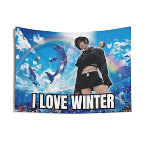 Puede incluir: Un tapiz con una mujer con un atuendo negro con un arcoíris y delfines en el fondo. El texto "I LOVE WINTER" está impreso en el tapiz.
