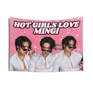 Peut inclure: Tapisserie rose avec le texte "HOT GIRLS LOVE MINGI" et trois images d'une personne portant des lunettes de soleil et une chemise blanche. Le fond présente un motif d'étoiles blanches.