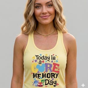 May include: A light yellow ribbed tank top with the text "Today is a Core Memory Day" in colorful letters. The design includes cartoon characters and heart shapes. The tank top is sleeveless.