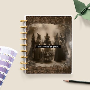 May include: A planner featuring a vintage-style image of five women in witch costumes standing in a forest. The text "Girls will be girls." is printed on the planner.
