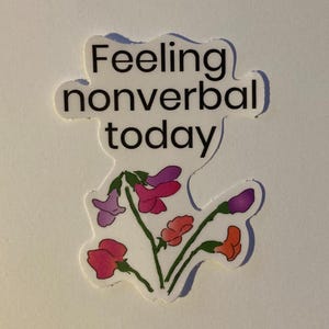 May include: A white sticker with the text "Feeling nonverbal today" and a drawing of purple, pink, and red flowers.
