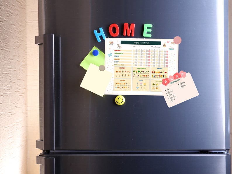 May include: A black refrigerator with a white magnetic chart titled "Mighty Munch Meter" with a grid for tracking food intake. The chart includes images of fruits, vegetables, grains, and dairy. There are also colorful magnetic letters spelling "HOME" and a smiley face magnet.