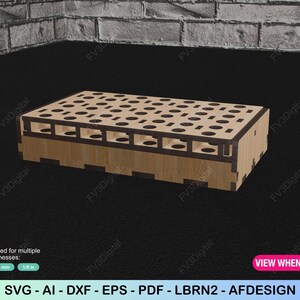 K&ouml;nnte beinhalten: Eine Holzbox mit Laser-Cut-Design, mit zahlreichen kreisf&ouml;rmigen &Ouml;ffnungen auf der Oberseite und rechteckigen Aussparungen an den Seiten. Die Box ist aus hellem Holz gefertigt und hat ein geometrisches Muster. Der Text "VIEW WHEN CLOSED" ist sichtbar.