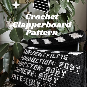 May include: A black and white crochet clapperboard pattern. The clapperboard has white text that reads "FIQUENT FILMS PRODUCTION: ROBY DIRECTOR: ROBY CAMERA: ROBY DATE: JULY 13 2024". The top of the clapperboard has a white and black pattern.
