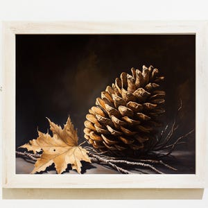 Puede incluir: Una pintura enmarcada de una gran piña de pino marrón y una sola hoja marrón sobre un fondo oscuro.