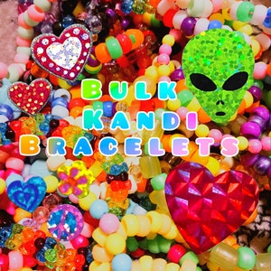 May include: A vibrant assortment of colorful kandi bracelets. The image features a variety of bead colors, including pink, yellow, green, and blue. Decorative heart and alien-shaped embellishments are scattered throughout the bracelets. Text reads "BULK KANDI BRACELETS."
