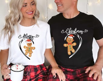 Pode incluir: T-shirts brancas e pretas com desenhos de bonecos de gengibre a condizer. A t-shirt branca diz "Merry" acima de um boneco de gengibre a usar um gorro de Pai Natal. A t-shirt preta diz "Christmas" acima de um boneco de gengibre a condizer.