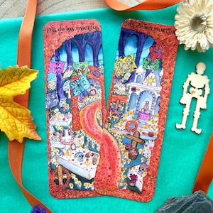 Peut inclure: Deux marque-pages colorés avec le texte "Dia de los muertos" sur chacun. Les marque-pages présentent un thème du Jour des Morts avec une scène de cimetière, des bougies et des fleurs.