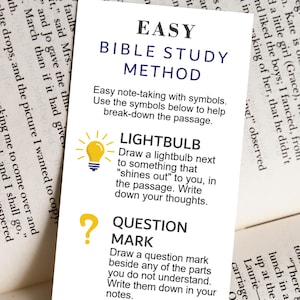 Peut inclure: Un marque-page jaune et blanc avec le texte "Easy Bible Study Method" et des instructions pour utiliser des symboles pour aider à décomposer un passage. Les symboles incluent une ampoule, un point d'interrogation, une flèche, une croix et une bulle de dialogue.