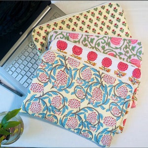 May include: A set of four laptop sleeves with different floral patterns. The sleeves are made of a soft, quilted fabric and feature a variety of colors, including pink, blue, and yellow.