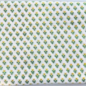 Puede incluir: Tela blanca con un patr&oacute;n repetitivo de peque&ntilde;as flores amarillas con tallos verdes.