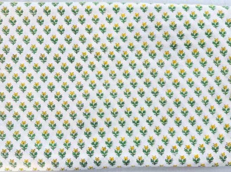 Puede incluir: Tela blanca con un patr&oacute;n repetitivo de peque&ntilde;as flores amarillas con tallos verdes.
