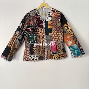 Puede incluir: Chaqueta patchwork con cuello en V y mangas largas. La chaqueta presenta una variedad de patrones de tela en tonos marrón, negro, verde y naranja. La chaqueta tiene dos bolsillos delanteros y el texto "ROOH EXPORTS" es visible.