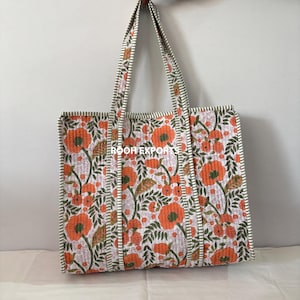 May include: A quilted tote bag with a floral pattern in orange, green, and white. The bag has two handles and the text "ROOH EXPORTS" is visible. The bag is made of a soft, quilted material.