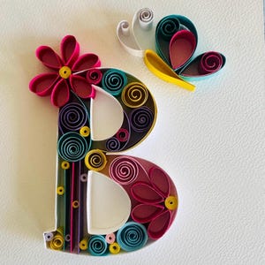 Può includere: Un cartello in legno fatto a mano con la scritta "Benvenuto" in stile scritto a mano. Il cartello è dipinto di bianco con una finitura invecchiata e una piccola foglia verde è attaccata in cima. Il cartello misura circa 30 cm di larghezza.