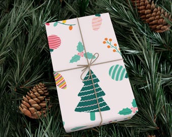 Könnte beinhalten: Ein verpacktes Geschenk mit einem festlichen Weihnachtsmuster. Das Geschenkpapier hat einen weißen Hintergrund mit bunten Illustrationen von Ornamenten, Weihnachtsbäumen und Stechpalmen. Das Geschenk ist mit Bindfaden gebunden und liegt auf einem Bett aus Tannennadeln und Tannenzapfen.