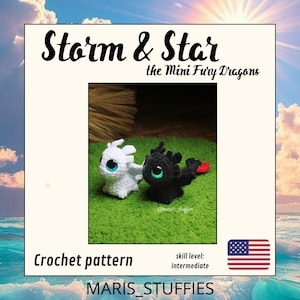 Op de afbeelding: Een haakpatroon met twee kleine drakenfiguren, één wit en één zwart, met respectievelijk blauwe en groene ogen. De zwarte draak heeft een rode staart. De tekst "Storm & Star" en "Crochet pattern" zijn zichtbaar. Het vaardigheidsniveau is gemiddeld.
