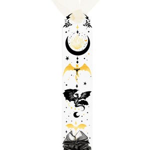 May include: White bookmark with black and gold illustrations of a crescent moon, stars, dragons, and books. A white ribbon is attached at the top. The bookmark is a fantasy-themed item.