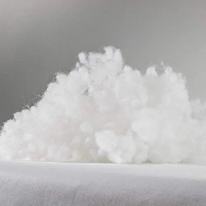 Op de afbeelding: Een grote stapel witte, pluche vulling. Dit type vulling wordt vaak gebruikt in kussens, kussens en knuffels.