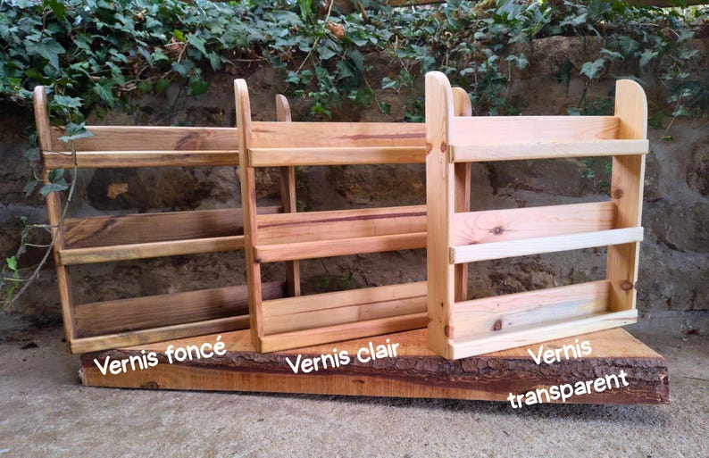 May include: Three wooden spice racks with varying finishes: dark, light, and transparent. Each rack has two shelves and a backboard. The racks are mounted on a natural wood base. Text on the base reads "Varnish" followed by a color description.