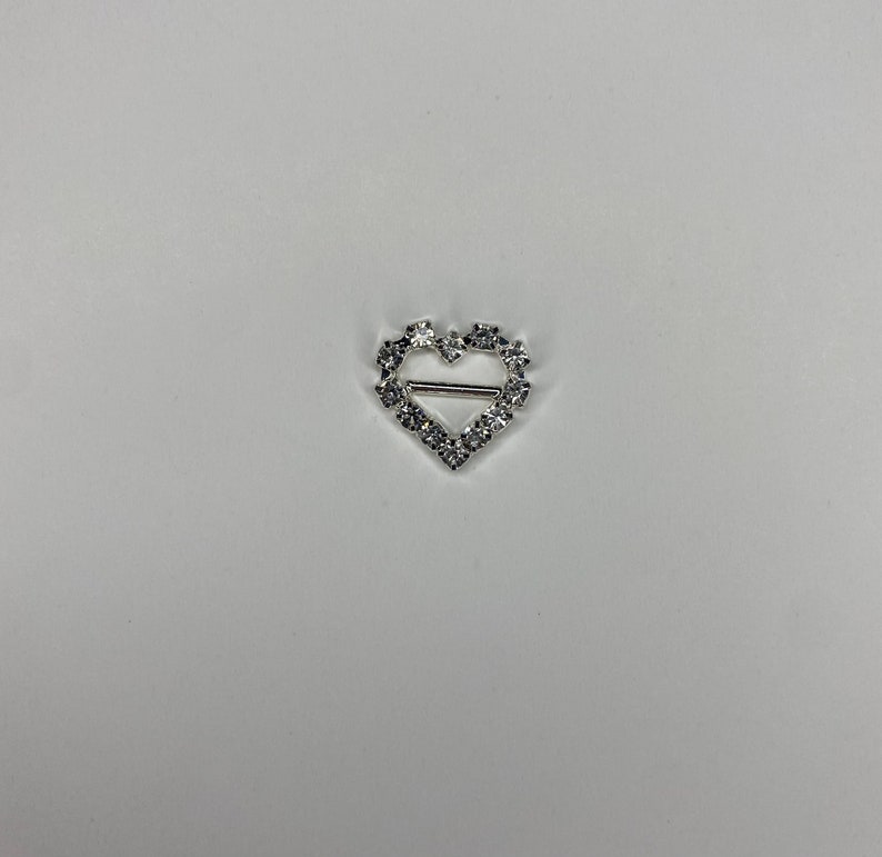 May include: Silver heart-shaped buckle with clear rhinestones.