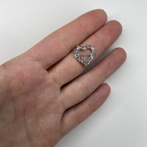 May include: A silver heart-shaped buckle with clear rhinestones.
