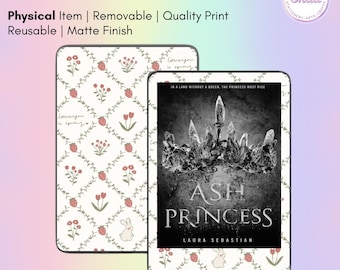 May include: E-reader sticker skin with a matte finish. One skin features a floral pattern with strawberries, flowers, and a bunny. The other skin displays the book cover of "Ash Princess". The text "E-Reader Sticker Skin" is at the top.