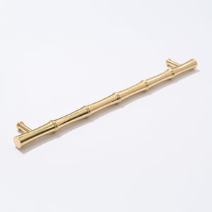 May include: A gold-toned bamboo-style pull handle for cabinets or drawers.