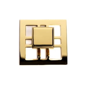 May include: A gold-toned metal cabinet knob with a square design. The knob has a raised, square center piece.