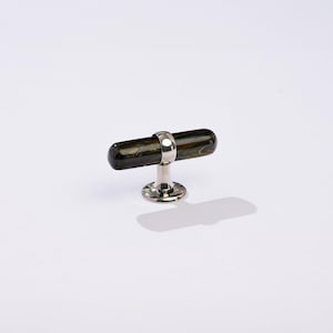May include: A dark green and black glass cabinet knob with a silver base and ring.