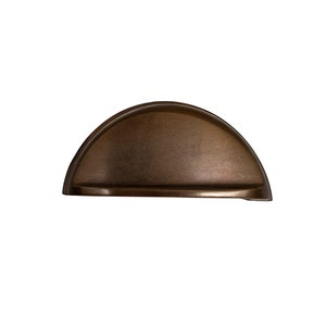 May include: A half-round cabinet knob with a brushed bronze finish.