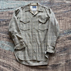 Op de afbeelding: Een overhemd met lange mouwen in een ruitpatroon van groen, bruin en blauw. Het heeft twee borstzakken en manchetten met knopen. De kraag is lichtbruin van kleur. Het overhemd heeft een knoopsluiting.