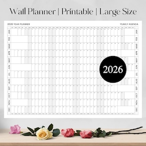 Peut inclure: Un grand planificateur mural imprimable pour 2026 avec une mise en page d'agenda annuel. Le design noir et blanc présente une grille pour chaque jour de l'année, avec l'année 2026 affichée en évidence dans un cercle noir. Le texte en haut indique "Wall Planner | Printable | Large Size."