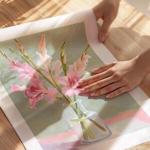 May include: A painting of a bouquet of pink and white gladioli flowers in a clear glass vase on a light green background.