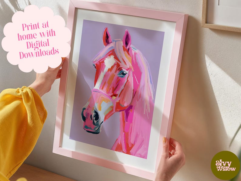 Peut inclure: Une peinture d'une t&ecirc;te de cheval rose sur un fond violet. Le cheval a une bande blanche sur le nez et porte une bride rose. La peinture est encadr&eacute;e dans un cadre rose.