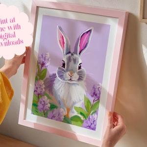 K&ouml;nnte beinhalten: Ein digitaler Druck eines grauen Kaninchens mit rosa Ohren, umgeben von lila Blumen auf einem helllila Hintergrund. Der Druck ist in einem rosa Rahmen gerahmt.